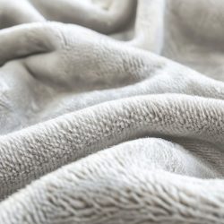 Close-up view of beige microfiber fabric with a soft, velvety texture. the fabric features a detailed, plush surface, showcasing its high-quality material. ideal for use in interior decoration, textile design, and fashion applications due to its luxurious and comfortable feel.